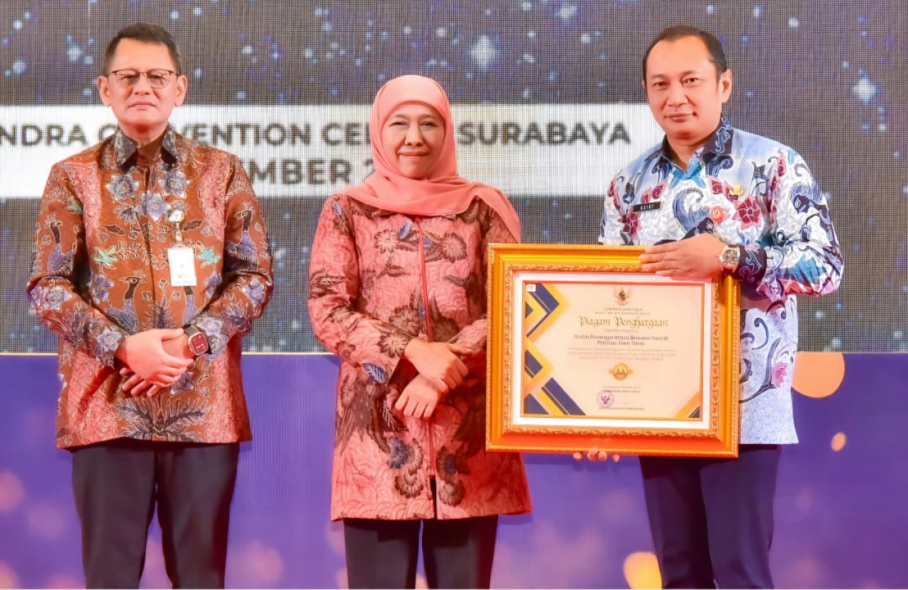 Gubernur Jatim Khofifah Indar Parawansa (tengah) saat memberikan penghargaan kepada Kepala BPBD Jatim Gatot Soebroto, Minggu 14 Desember 2025.