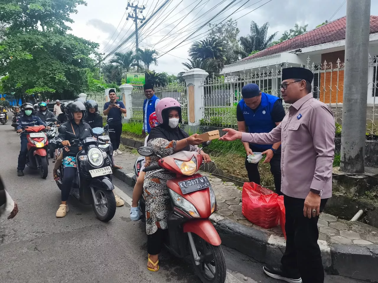 Ketua DPW PAN Kaltim Erwin Izharuddin saat memberikan takjil kepada pengendara yang melintas di daerah Teluk Lerong, Sabtu, 7 Maret 2026.