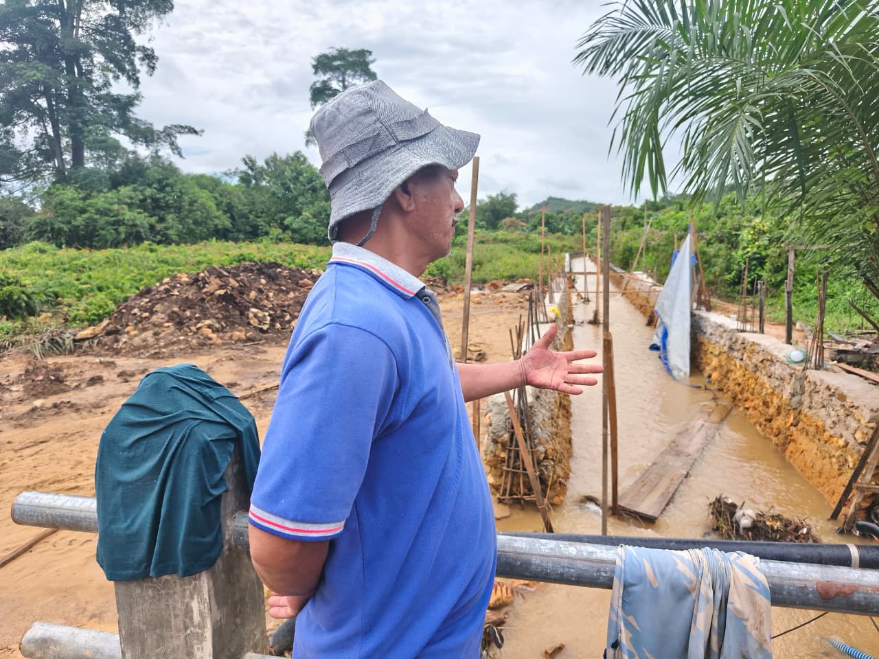 Marthen Tappi Sanda saat memperlihatkan drainase yang sedang dibangun. Drainase itu diduga menjadi penyebab banjir di daerahnya.