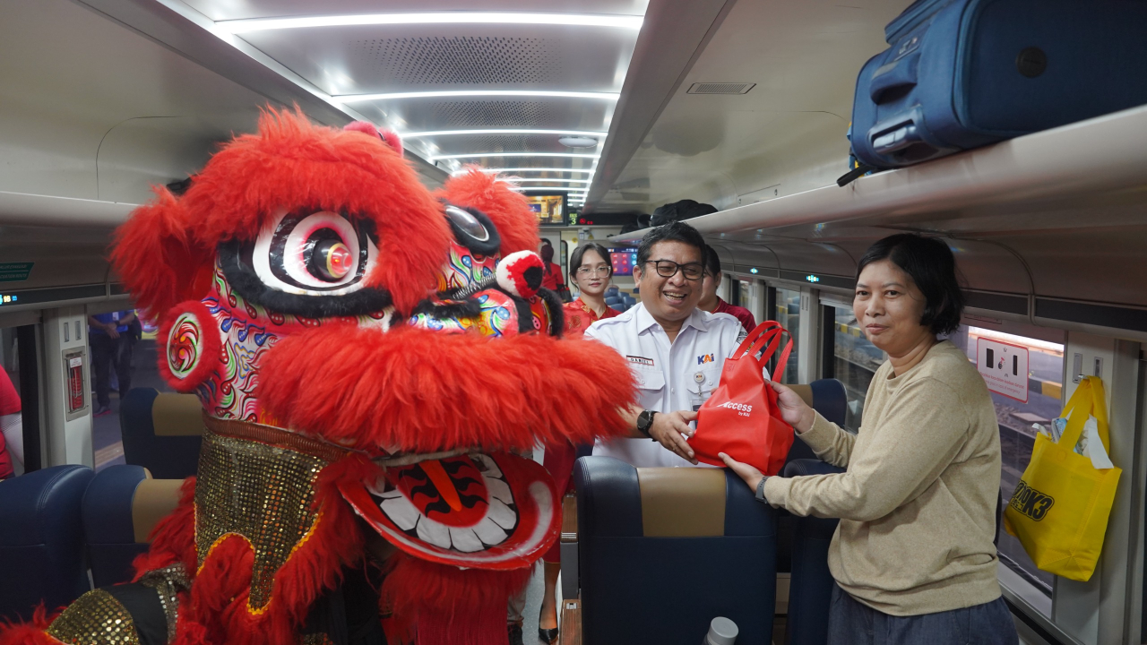 Salah satu petugas KAI Daop 8 Surabaya yang memberikan hadiah imlek kepada pelanggan.