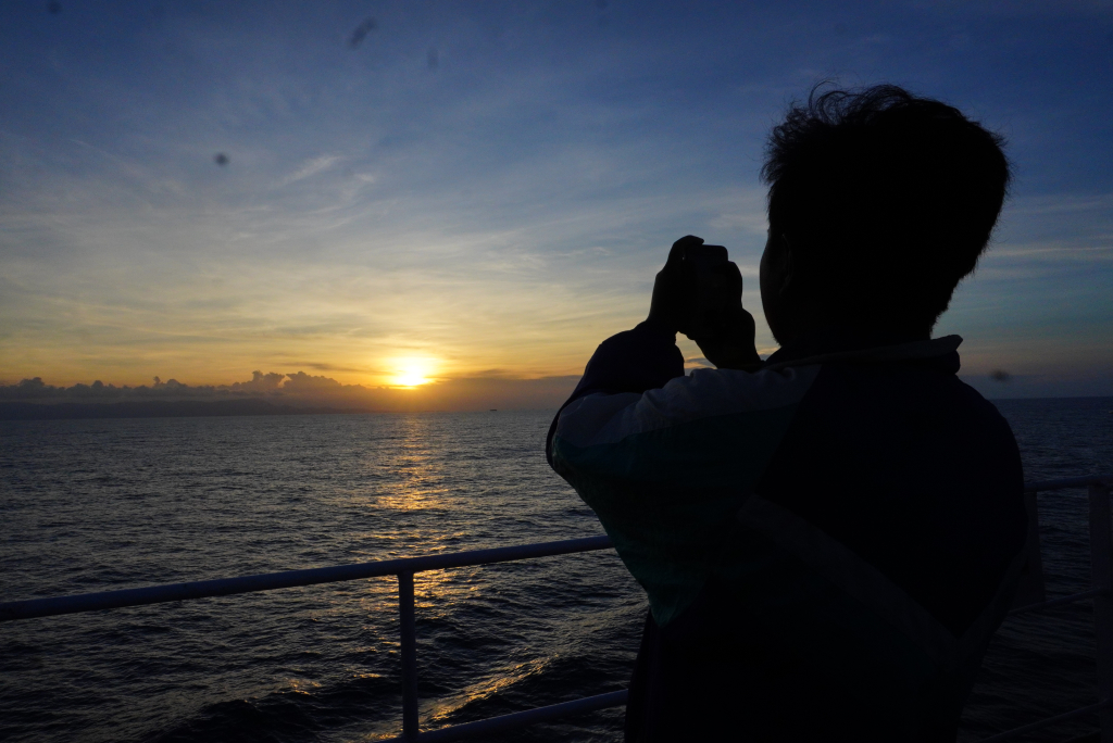 Salah satu penumpang yang mengabadikan sunset di atas KM Dharma Ferry 7. (Foto: Michael Fredy Yacob)